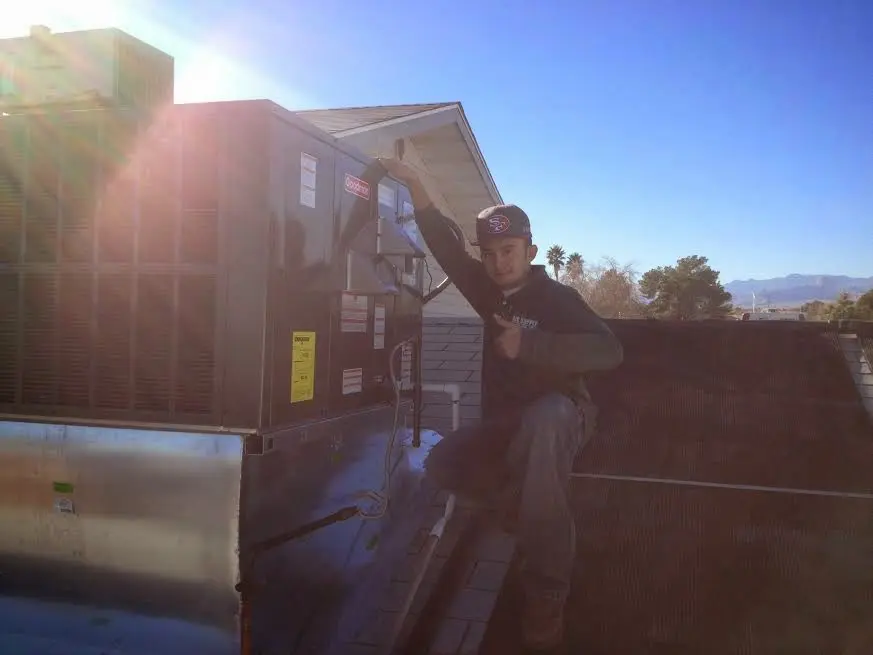 HVAC technician performing Air Duct Repair on a rooftop unit in Greenville